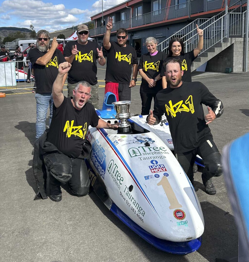 Burt Wolland (kneeling left) and Vaughan Maine and crew celebrate their NZ Sidecar title